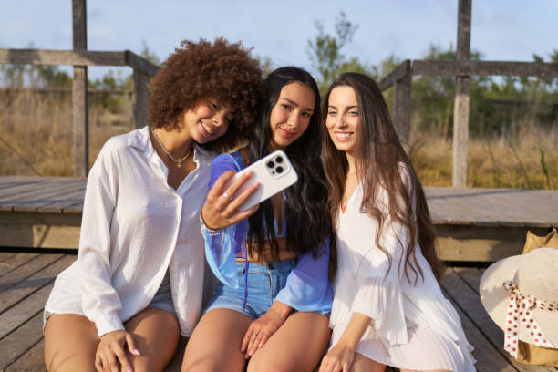 istock Three women are sitting on a wooden platform 2156062522
