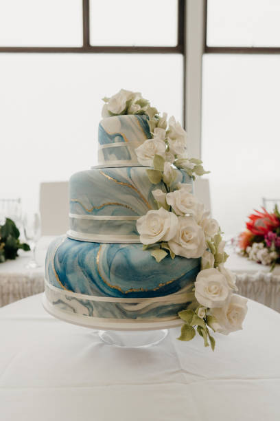 istock a large wedding cake is displayed with white roses and blue frosting 2156062783