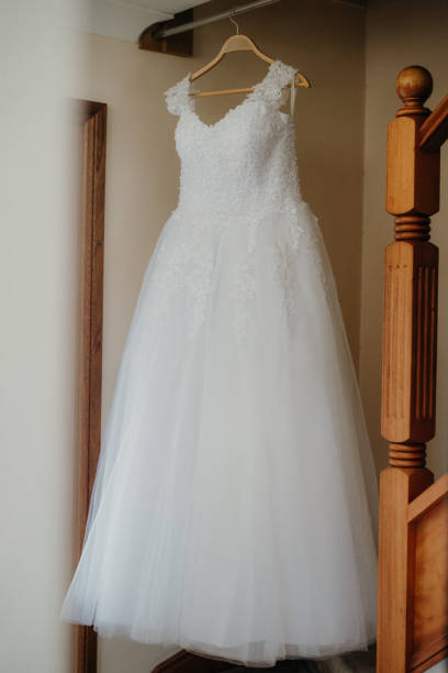 istock a brides wedding dress hangs from a rail on a staircase 2156062825