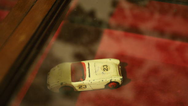 A yellow toy car parked in front of a window