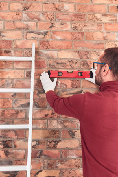 istock Handyman with spirit level working in a new home interior. 2156063424