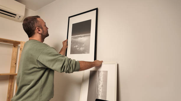 istock Man hanging pictures on the wall. 2156063461