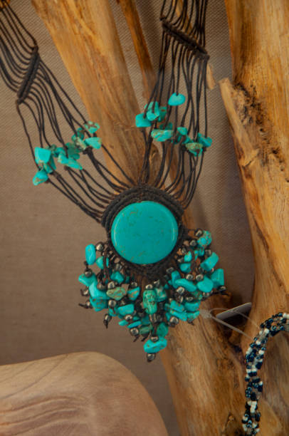 istock Turquoise necklace with black wires and beads, placed against a tree 2156064061
