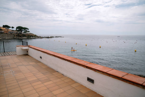 Balcony with tiled floor overlooking ocean during day
