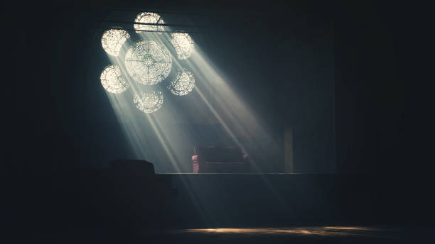 istock Streams through a flower shaped window into a dark room with a -table 2156064751