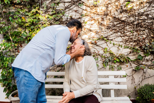 Son kissing his mother forehead at nursing home