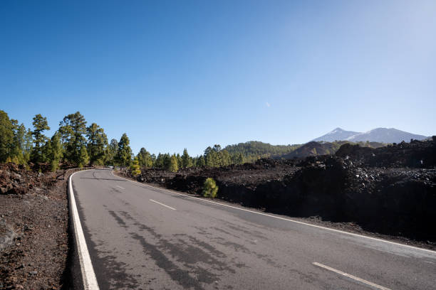 istock a scenic highway running along side a volcano with a single car driving along it 2156067165