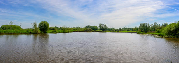 istock Panoramic view of a Belgian nature reserve with a pond, forests, and a blue sky 2156068883