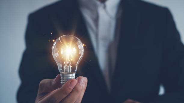 istock Idea innovation and inspiration concept.Hand of man holding illuminated light bulb, Idea innovation and inspiration concept.  creativity with bulbs that shine glitter, Concept for success. 2156071409