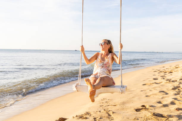 istock Woman Enjoying a Swing on a Sunny Beach 2156072492