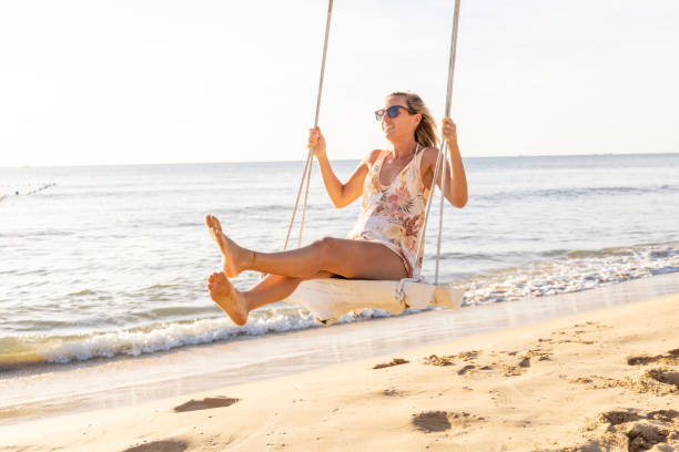 Woman Enjoying a Swing on a Sunny Beach