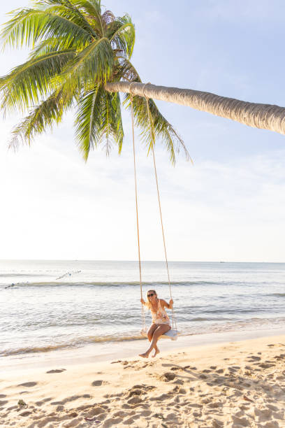 istock Woman Enjoying a Swing on a Tropical Beach 2156072613