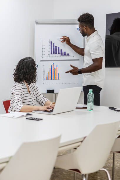 istock Business Professional Presenting Data Graphs To Coworker During Meeting 2156074054