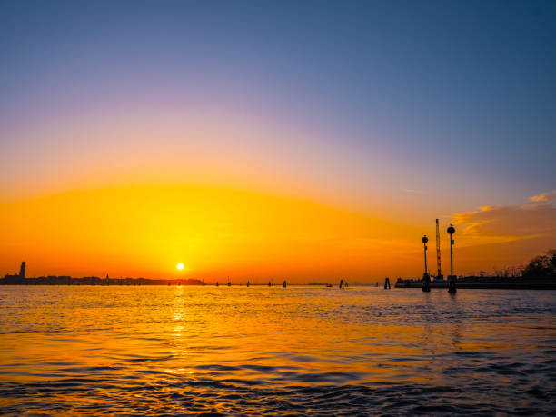 Venice, Italy. 29 october 2022. silhouettes of Venice at sunset in the bright warm orange-red rays of the setting sun. view from the water