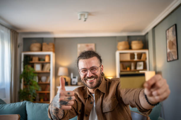 istock Satisfied smiling young man showing credit card 2156077568