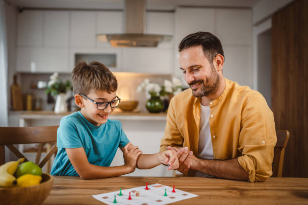 istock Father and son play board game have fun together at home 2156086391