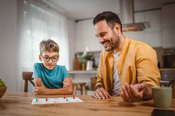 istock Father and son play board game have fun together at home 2156086658
