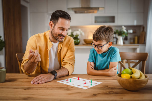 istock Father and son play board game have fun together at home 2156086740