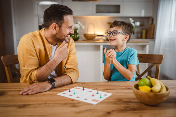 istock Father and son play board game have fun together at home 2156086842