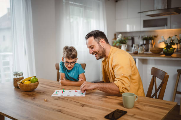 istock Father and son play board game have fun together at home 2156087351