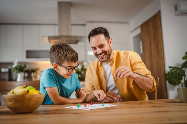 istock Father and son play board game have fun together at home 2156087713