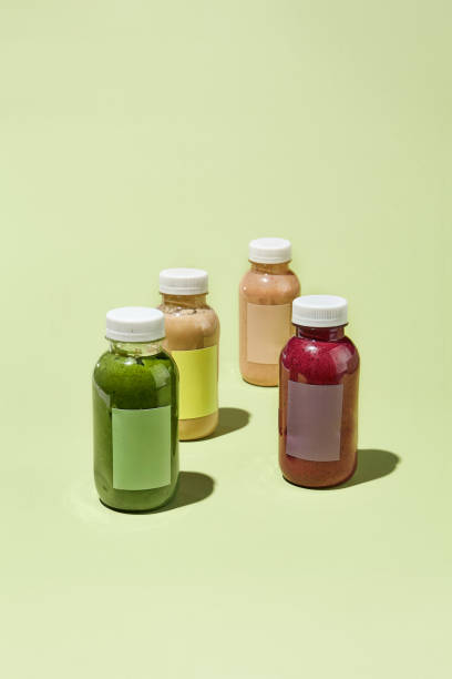 istock Colorful Detox Juice Bottles on Pastel Background in Minimalistic Pattern for Cleansing Program 2156088352