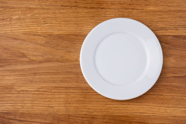 istock Empty white plate on wooden background, right position. 2156088402