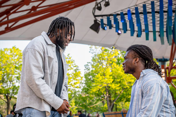 istock Lively Downtown Gathering: Young Black Men Conversing Amidst a Crowd in Winnipeg 2156090916