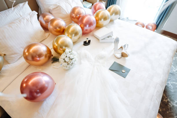 White balloons hang from the ceiling, creating a festive atmosphere in a bright room. Soft lighting enhances the cheerful vibe, perfect for a celebration or gathering.