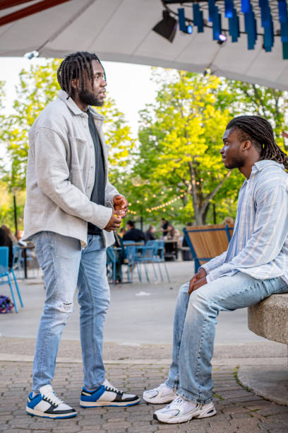 istock Lively Downtown Gathering: Young Black Men Conversing Amidst a Crowd in Winnipeg 2156092417