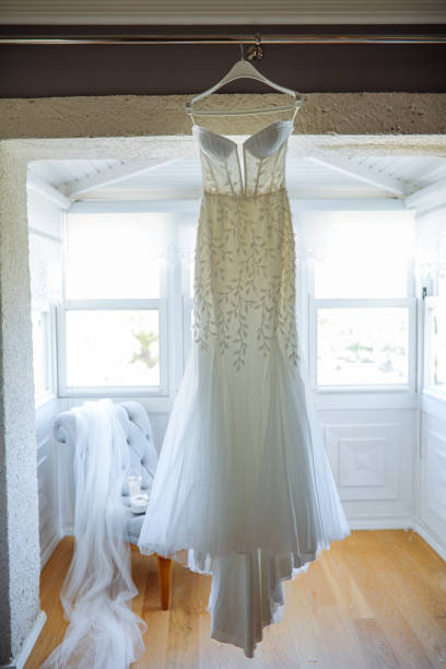 Beautiful white wedding dress and shoes for bride indoors. Beauty of bridal gown for marriage. Female lace clothes for celebration