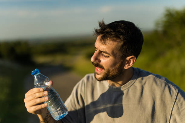 istock Young male athlete drinking fresh water while on a sports training outdoors in nature. 2156099313
