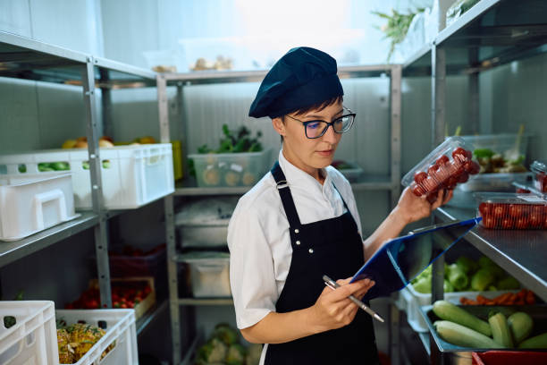 Female cook checking kitchen's supplies while working in a restaurant.