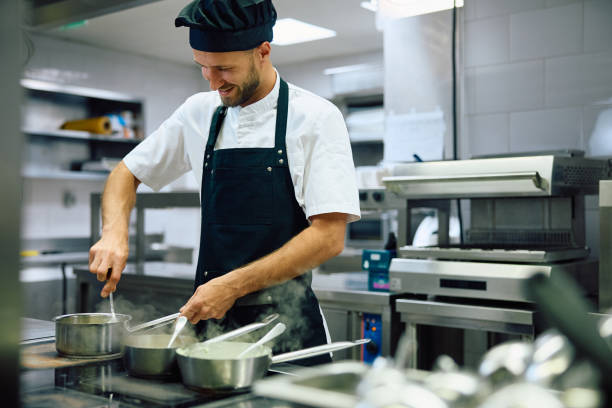 istock Happy chef cooking while working in the kitchen in restaurant. 2156105480