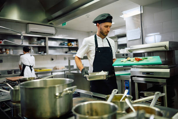 istock Male chef preparing food in the kitchen in restaurant. 2156105551