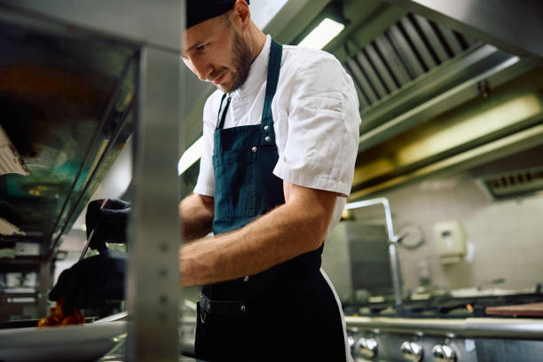 istock Focused cook making a dish in the kitchen in restaurant. 2156105637