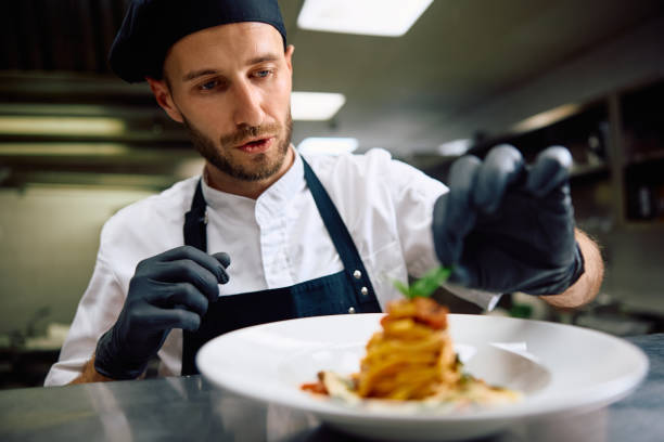 istock Chef decorating food plate while cooking in the kitchen. 2156105643