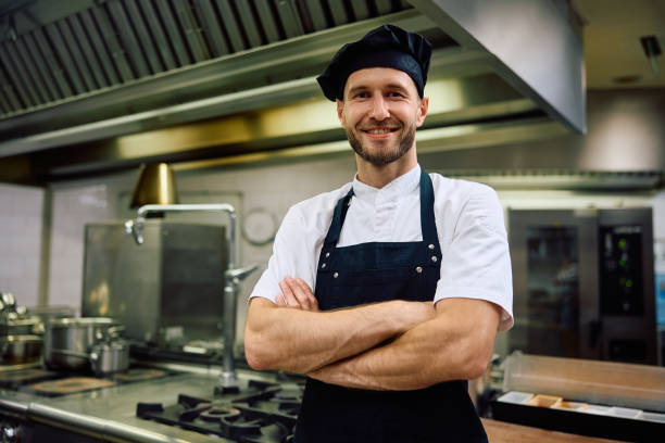 istock Happy chef with arms crossed in the kitchen looking at camera. 2156105662