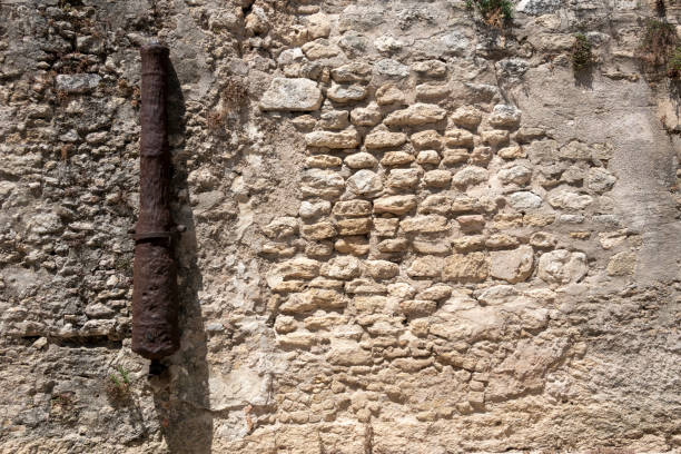 istock Stone wall decorated with an old iron cannon n Vejer de la Frontera, Spain. 2156105868