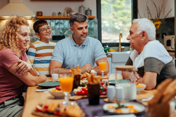 istock A family sitting at the table having breakfast and smiling 2156107484