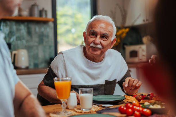 istock A white old man attentively listens while sitting at a table 2156107495