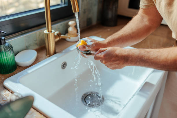 istock Close up of a man's hands washing a fork in the kitchen sink 2156107544