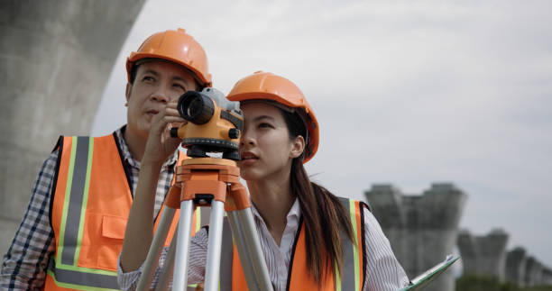 istock Senior construction male  engineer training a young new female  engineer and using a digital tablet with a hold walkie-talkie in his hand at the infrastructure of Sky bridge 2156109306