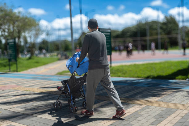 Bogotá Colombia 2 de junio de 2024:Dad walking his son in a car