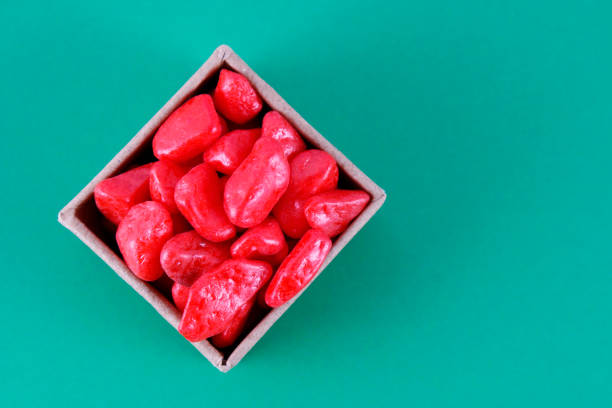 Top view of box containing red stones on green background