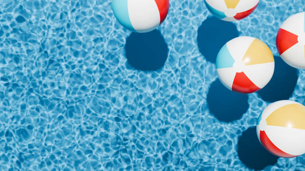 Summer holidays banner. Swimming pool top view. Beach ball in the empty clear pool.