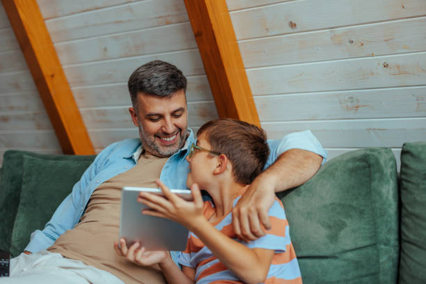 istock Son showing something funny on the tablet to his dad 2156114914