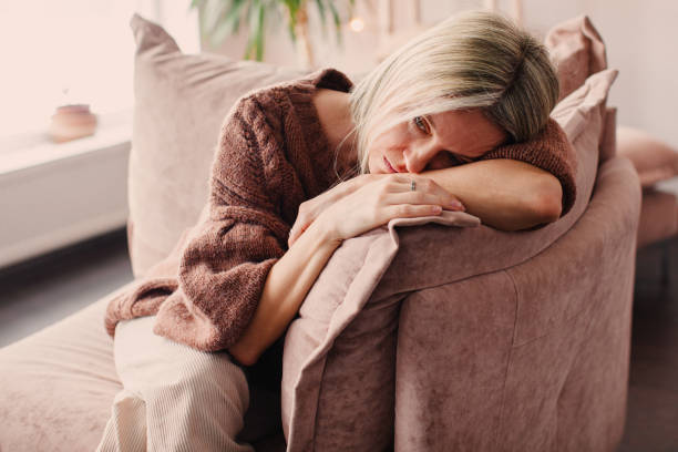 Frustrated Sad Woman sitting on Couch at Home