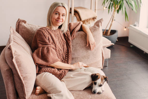 istock Cut Middle aged Woman sitting on couch at home 2156119489