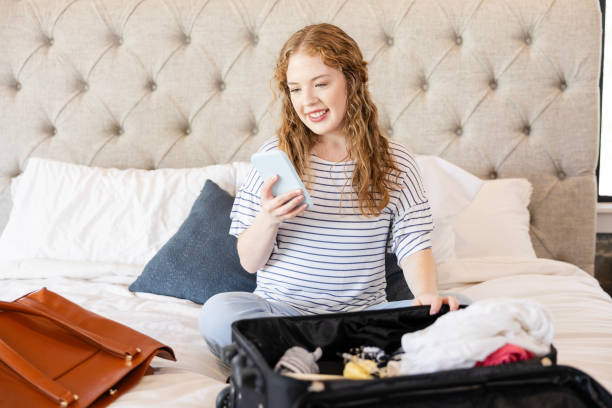 istock Young adult female smiles while reading a text message on her smart phone 2156120666
